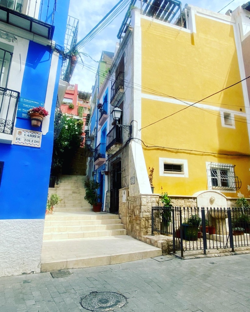 Alicante street, bright yellow and blue buildings and the sign CARRER DE TOLEDO